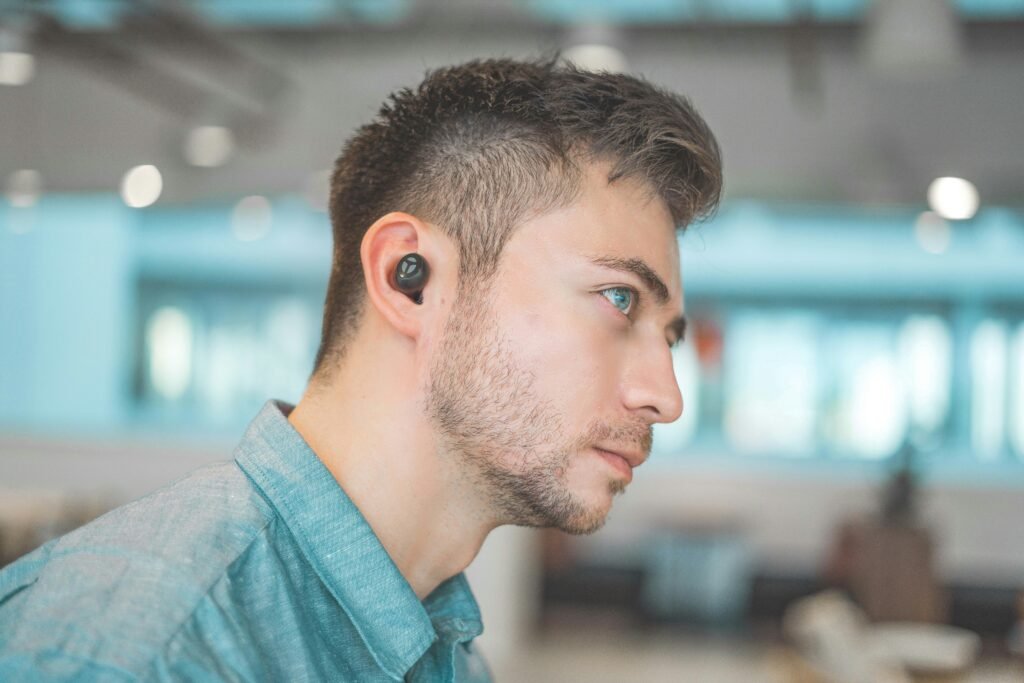 Man wearing wireless earbuds in a modern indoor setting